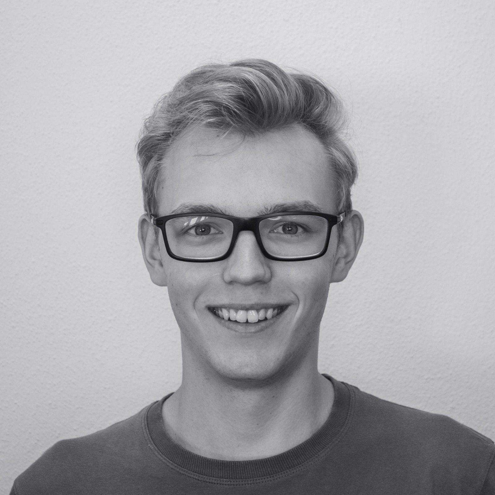 Lächelnder junger Mann mit Brille