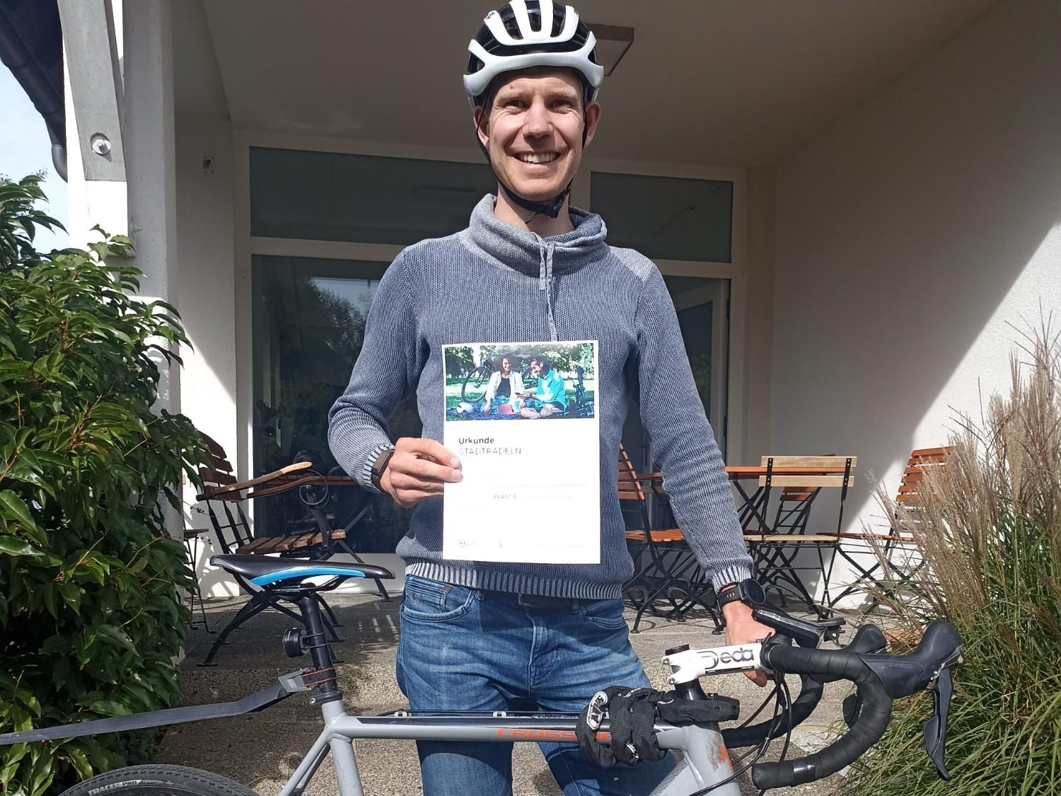 Mann mit Urkunde und Fahrrad